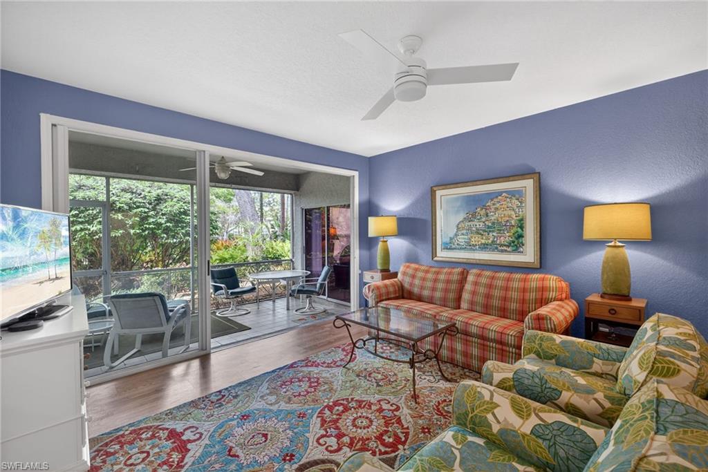 290 Emerald Bay Circle, Unit L7 Naples, FL 34110 - Photo 3 of 22 a living room with furniture and a floor to ceiling window