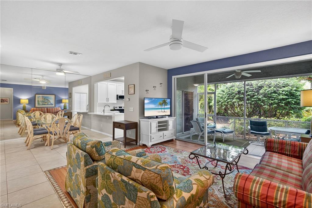 290 Emerald Bay Circle, Unit L7 Naples, FL 34110 - Photo 4 of 22 a living room with furniture and a large window