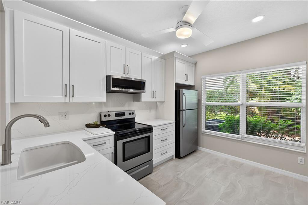 290 Emerald Bay Circle, Unit L7 Naples, FL 34110 - Photo 6 of 22 a kitchen with refrigerator a sink and a stove