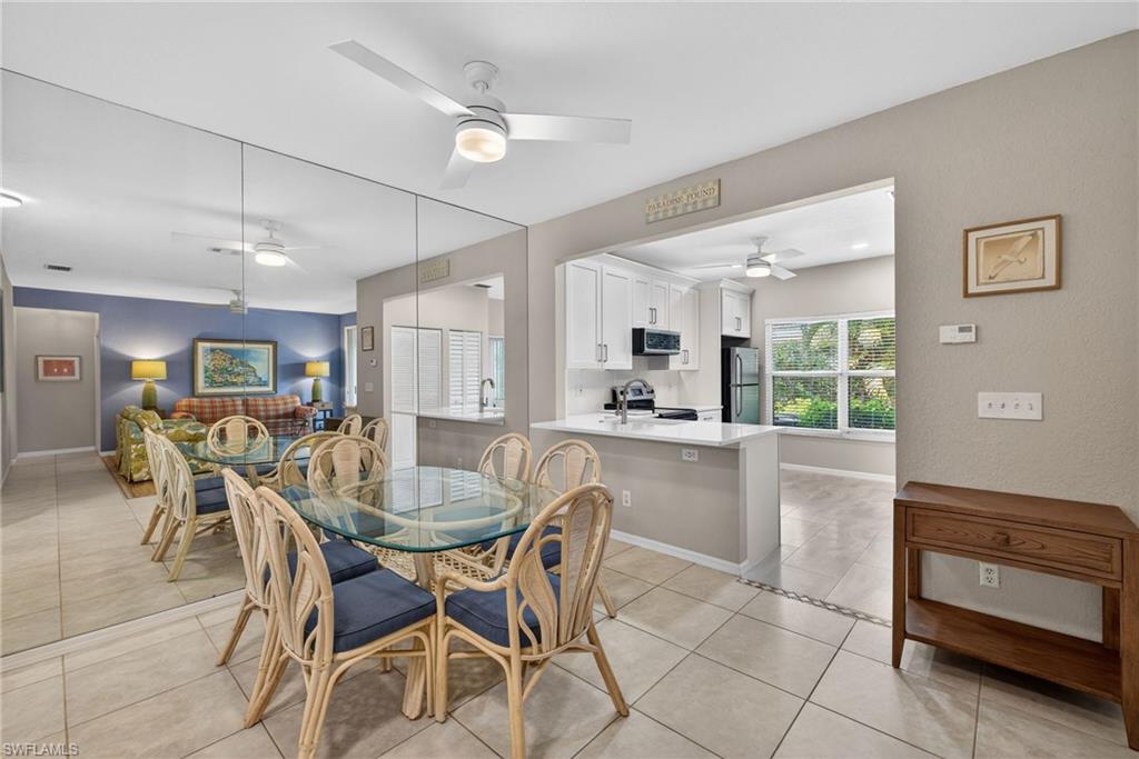 290 Emerald Bay Circle, Unit L7 Naples, FL 34110 - Photo 8 of 22 a dining area with a table chairs and a kitchen view