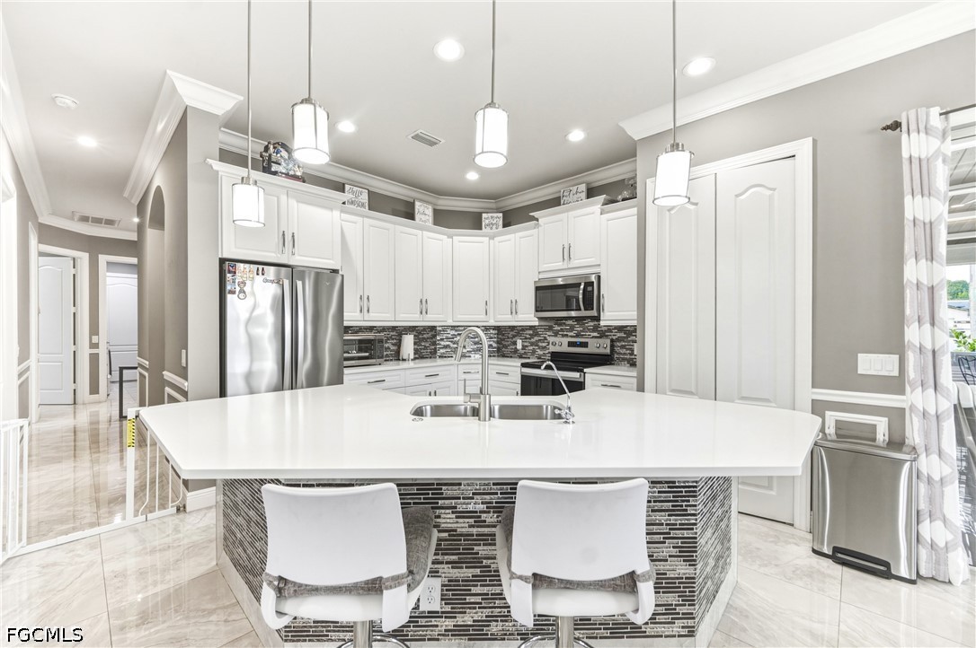 1700 43rd Terrace Southwest Naples, FL 34116 - Photo 24 of 38 a kitchen with stainless steel appliances a kitchen island hardwood floor and a sink