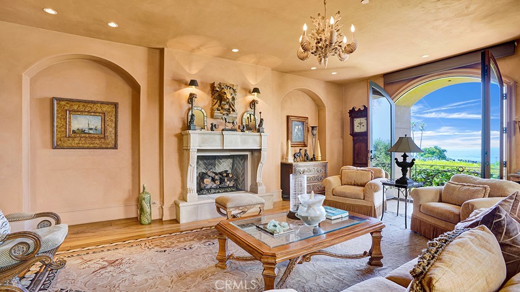 26 Ritz Cove Drive Dana Point, CA 92629 - Photo 15 of 66 a living room with furniture a chandelier and a fireplace