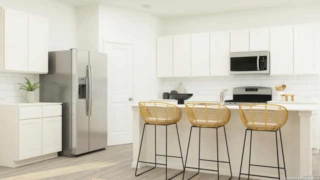 a kitchen with stainless steel appliances a refrigerator a stove a microwave a sink and white cabinets