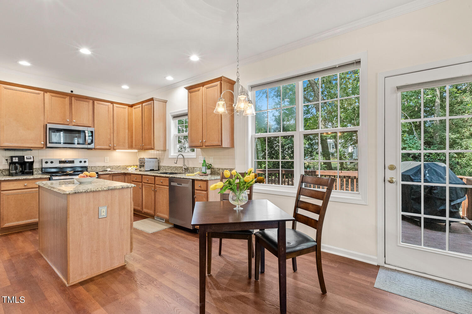 2013 Prairie Ridge Court Fuquay-Varina, NC 27526 - Photo 10 of 53 a kitchen with kitchen island granite countertop wooden floors and white appliances