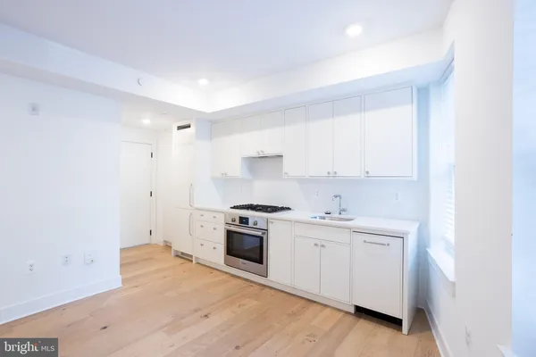 a kitchen with a stove top oven and sink
