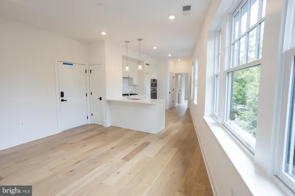 a view of a hallway with wooden floor and windows
