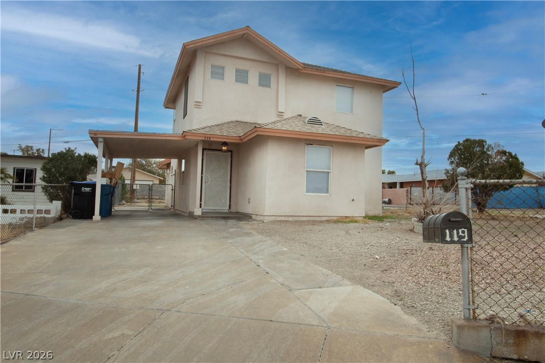 119 West Victory Road Henderson, NV 89015 - Photo 26 of 26 A modest stucco residence features an integrated carport and a functional chain link fence.