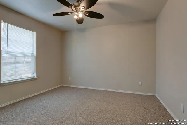 an empty room with a window and a fan