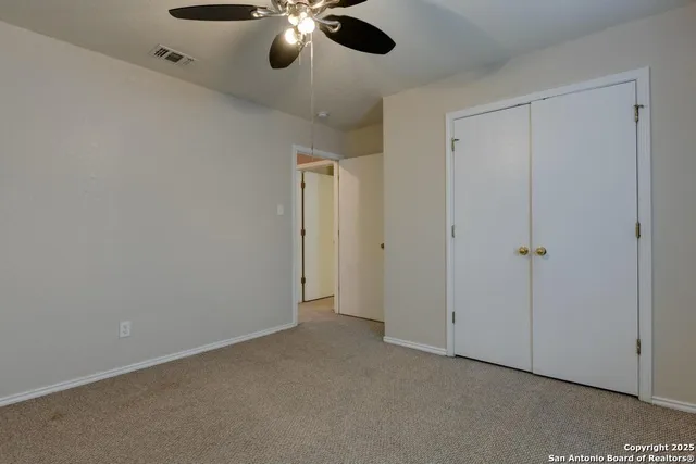 an empty room with a window and a fan