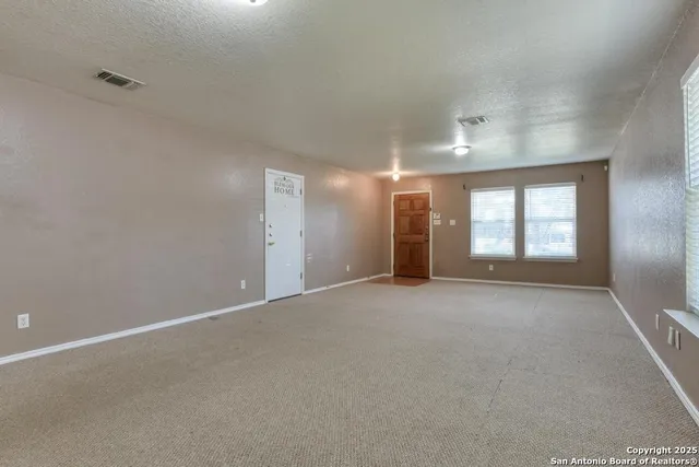 a view of a big room with windows and chandelier fan