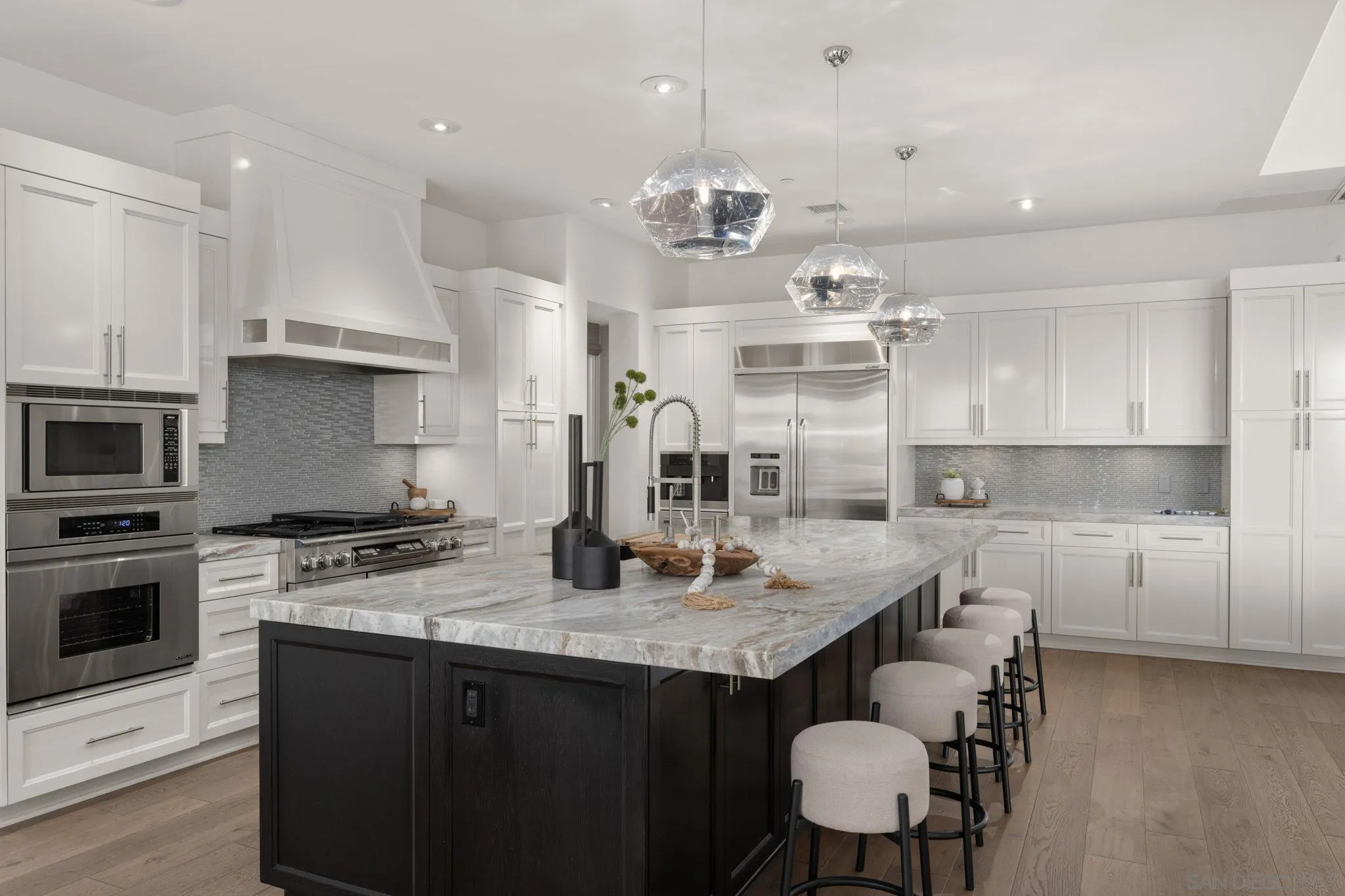 6968 St Andrews Road Rancho Santa Fe, CA 92067 - Photo 7 of 23 a kitchen with kitchen island granite countertop a sink a center island and cabinets