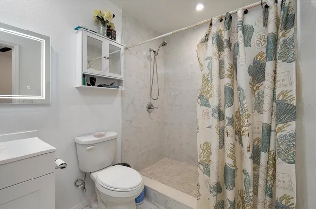 a white toilet sitting next to a bathroom sink