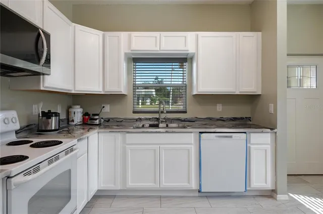 a kitchen with stainless steel appliances granite countertop a sink a stove and a microwave