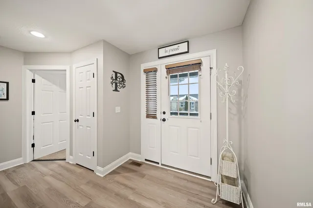 a view of a hallway with wooden floor and windows