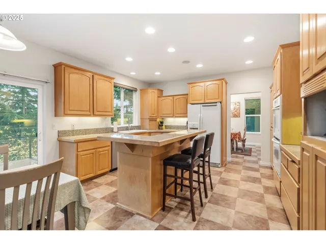 a kitchen with kitchen island granite countertop wooden floors granite top and stainless steel appliances