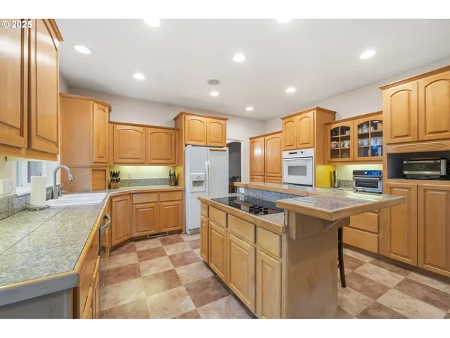 a kitchen with stainless steel appliances granite countertop a sink a stove and cabinets
