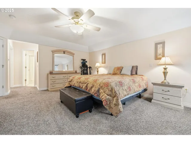 a spacious bedroom with a bed and a chandelier