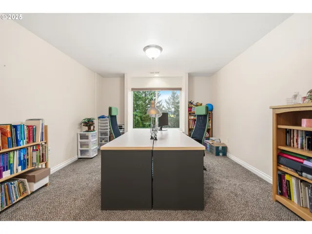 a view of a workspace with furniture and a bookshelf