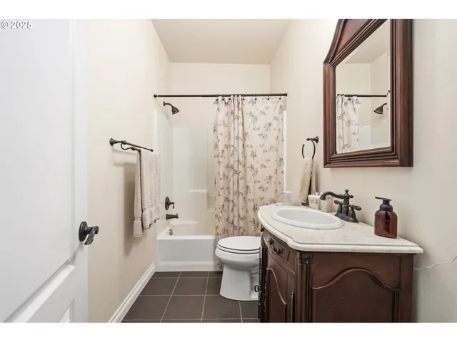 a bathroom with a sink a toilet a mirror a vanity and shower