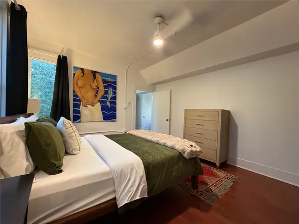 a bedroom with a bed and a flat tv screen on dresser