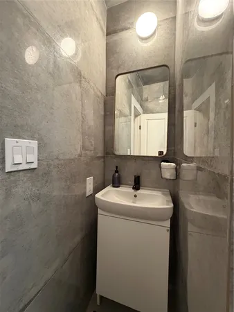 a bathroom with a sink a toilet and mirror