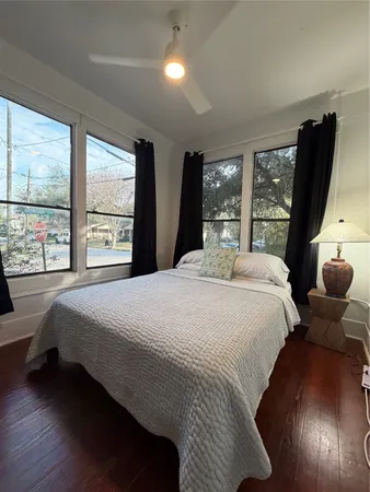 a bedroom with a bed and large windows