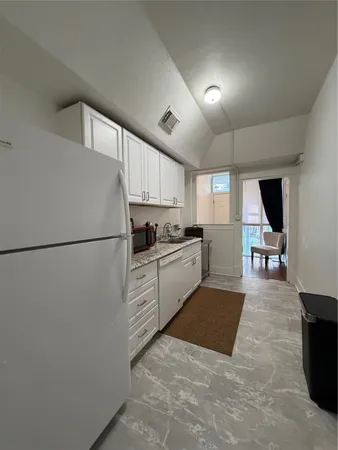 a kitchen with a refrigerator a stove and a sink