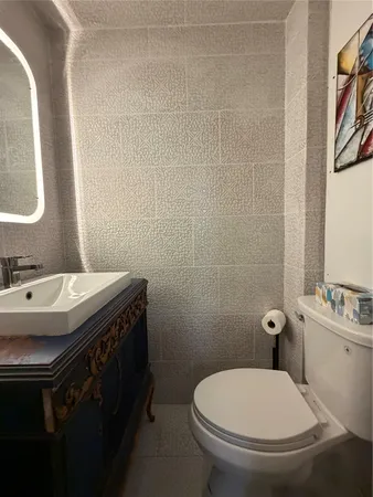 a bathroom with a toilet sink and mirror