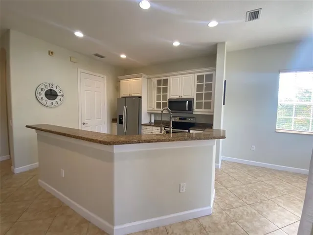 a kitchen with stainless steel appliances granite countertop a refrigerator a stove and a sink