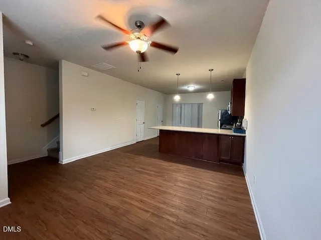 an empty room with wooden floor and a hallway