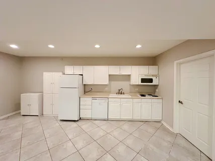 a kitchen with white cabinets and white appliances