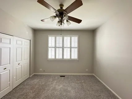 an empty room with a window and a fan