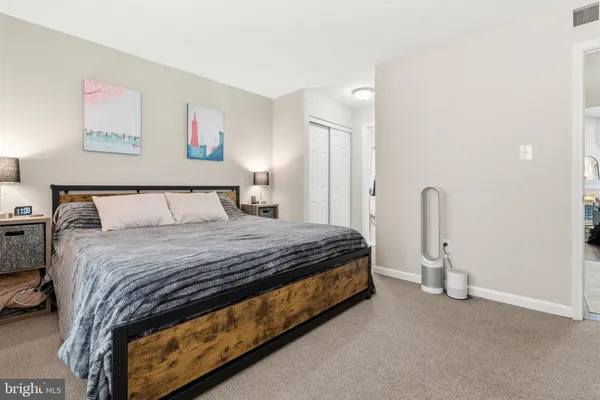 a bedroom with a bed and a painting on the wall