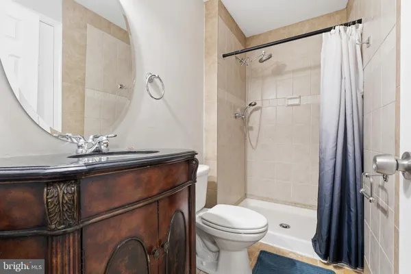 a bathroom with a sink a toilet a mirror and shower