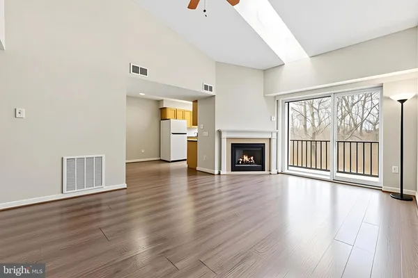 wooden floor fireplace and windows in an empty room