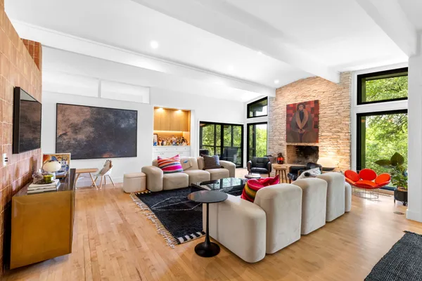 a living room with fireplace furniture and a large window
