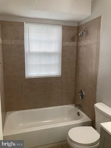 a bathroom with a bathtub toilet and window
