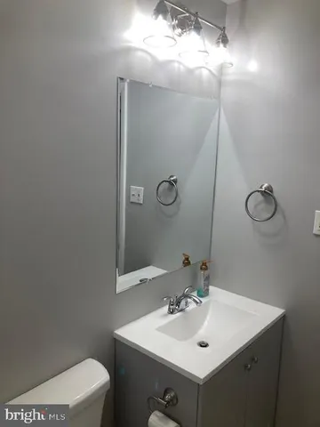 a bathroom with a sink mirror vanity and toilet