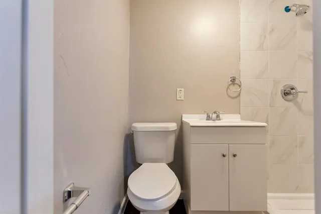 a bathroom with a toilet a sink and mirror