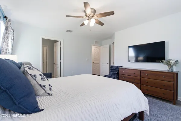 a bedroom with a large bed and a flat screen tv
