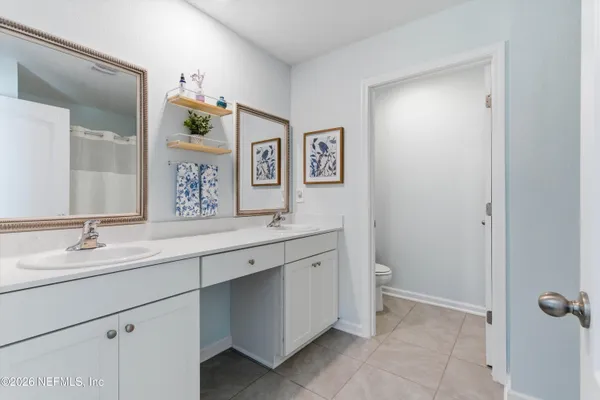 a bathroom with a granite countertop sink mirror and toilet