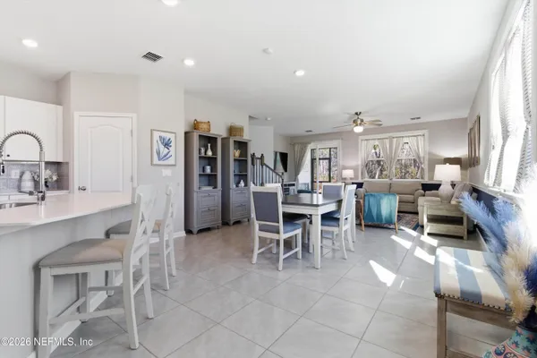 a living room with furniture a dining table and kitchen view