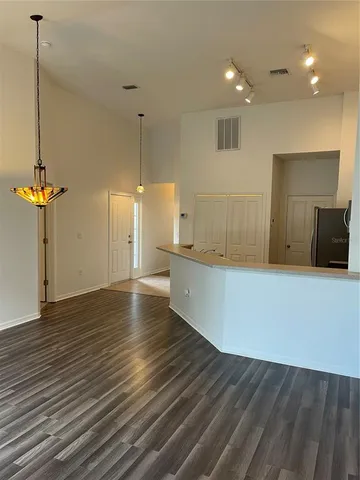 a view of a room with wooden floor and a ceiling fan