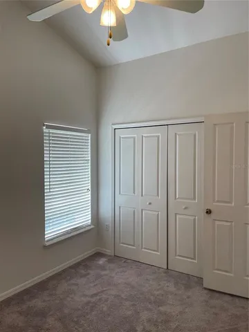 an empty room with a ceiling fan and a window