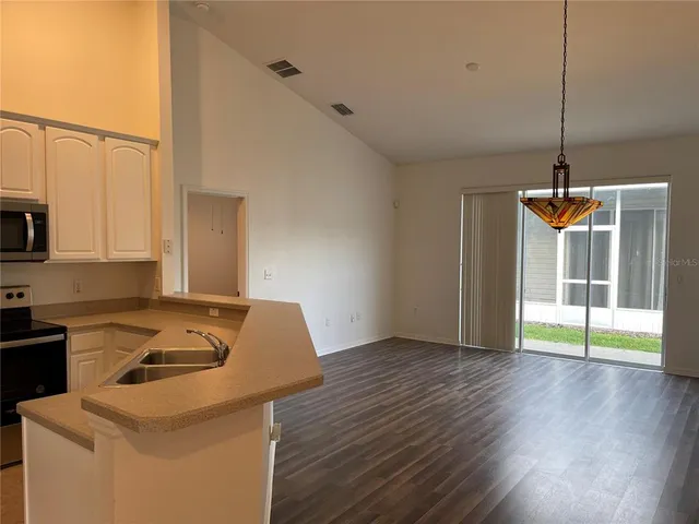 a kitchen that has a sink a stove and a wooden floor