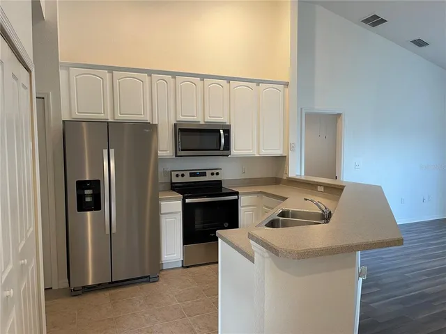 a kitchen with white cabinets and stainless steel appliances