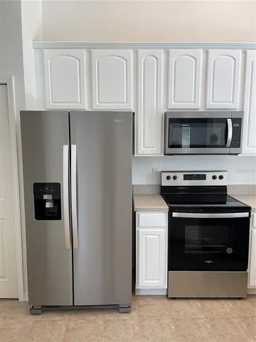a kitchen with white cabinets and stainless steel appliances