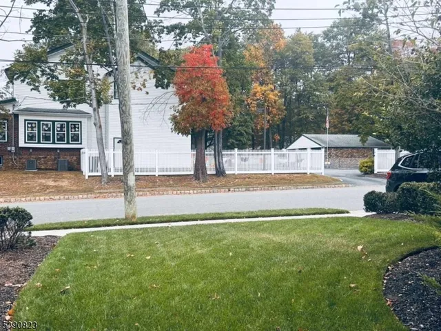 a view of an house with backyard and trees