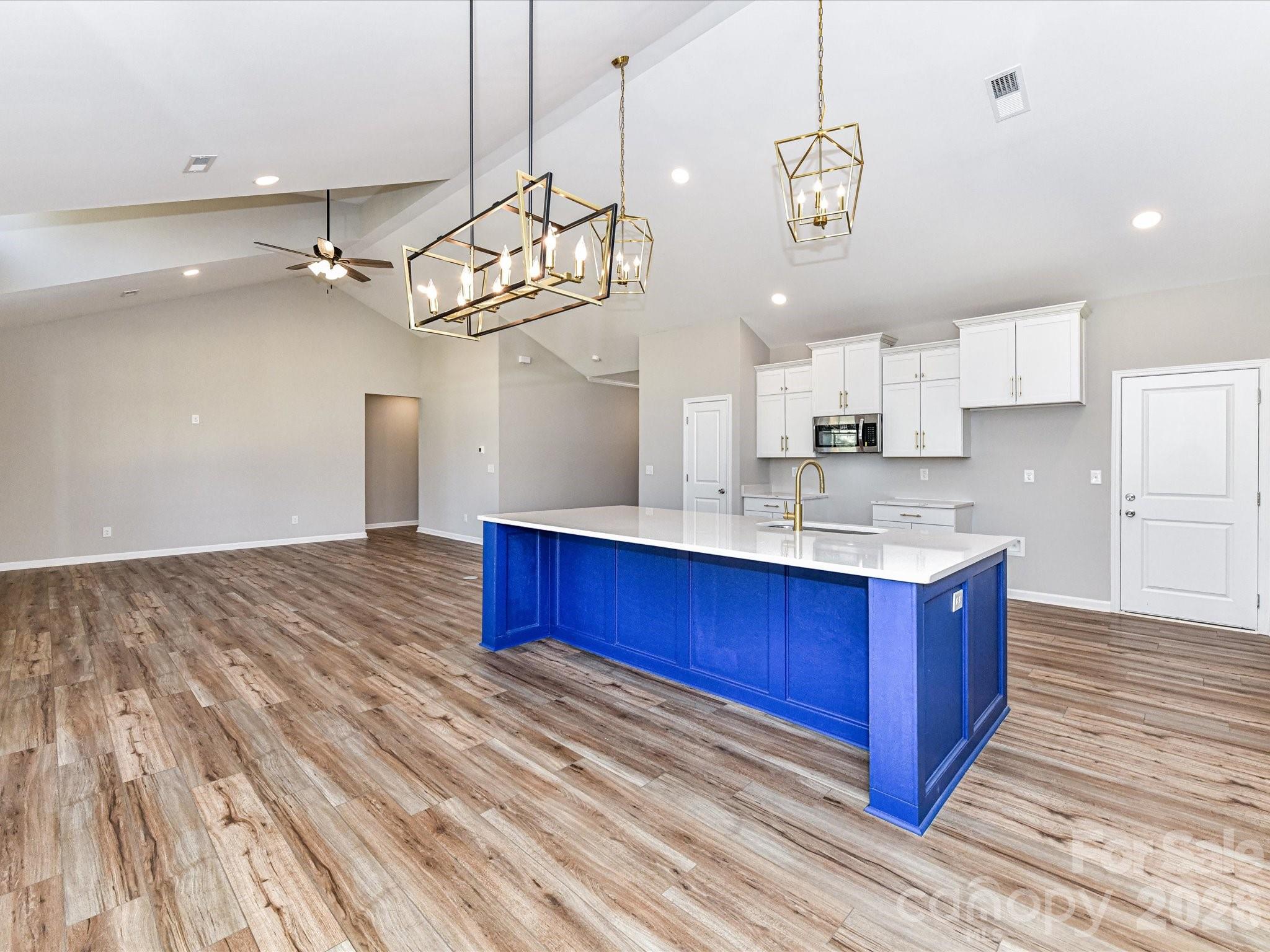104 Poplar Street Clover, SC 29710 - Photo 11 of 33 a kitchen with kitchen island granite countertop a sink cabinets and wooden floor