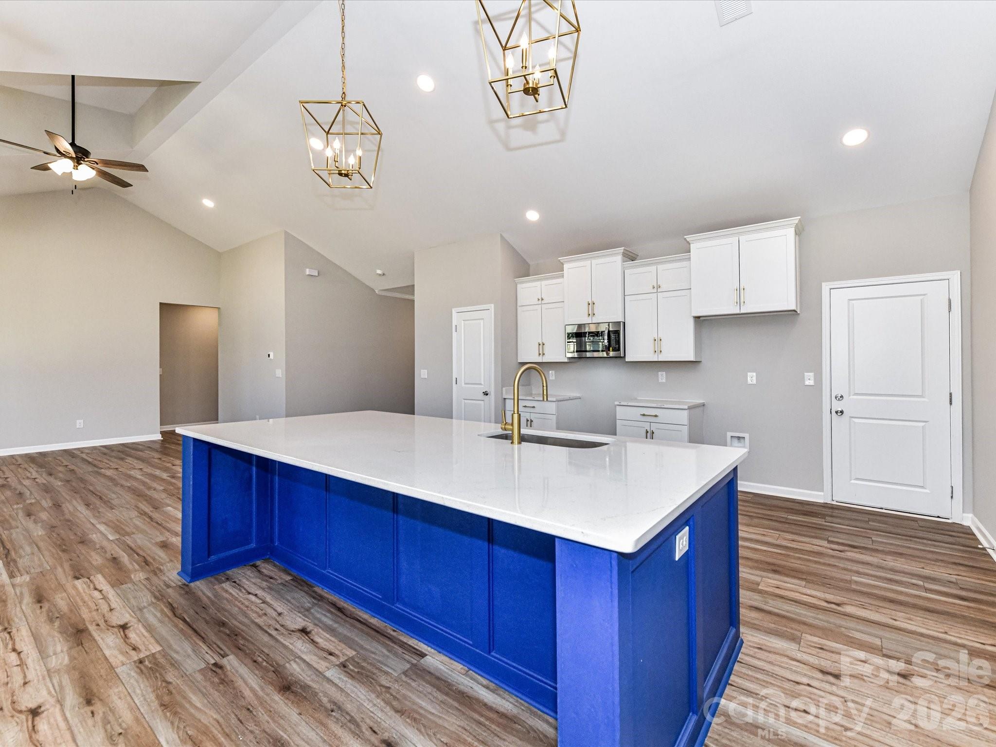 104 Poplar Street Clover, SC 29710 - Photo 12 of 33 a kitchen with kitchen island a wooden floor and window